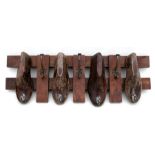A set of coat hooks made from cobbler's shoe lasts, 76cms (30ins) wide.