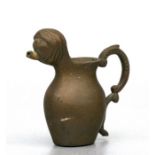A medieval style brass / bronze miniature jug with mask spout, 7cms (2.75ins) high.