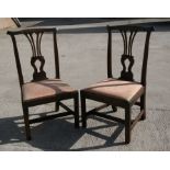 A pair of Georgian mahogany side chairs with drop-in upholstered seats, on square chamfered legs.