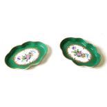 A pair of Herend pin dishes decorated with flowers with gilt highlights on a green ground, 14cms (