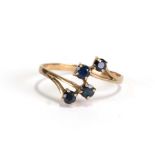A 9ct gold and sapphire four-stone cross-over ring, approx UK size 'O'.