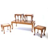 A walnut coffee table with four matching smaller tables, the coffee table 105cms (41.25ins) wide,