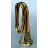 A Royal Welsh Fusiliers copper & brass bugle (lacks mouthpiece), 28cms (11ins) wide.