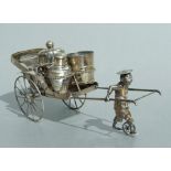 A Chinese white metal three-piece cruet set in the form of a rickshaw, 20cms (8ins) long.Condition