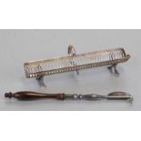 A George III style sterling silver pen trough with scroll handle, pierced decoration and shell