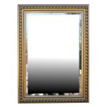 A modern gilt framed bevel edged wall mirror, 77 by 106cms (30.25 by 42ins).