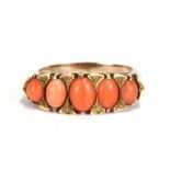 A yellow coloured metal and coral half hoop ring, approx UK size 'O'.