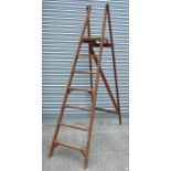 A pine folding six-step ladder.