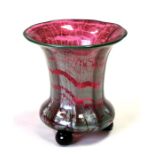 An Art glass vase standing on three ball feet, with ground out pontil mark, 15cms (6ins) high.