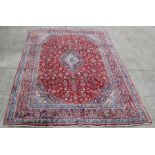 A Persian Mashad woollen hand knotted carpet with central floral medallion within floral borders