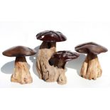A group of three carved rootwood garden mushrooms, the largest 43cms (17ins) high (3).