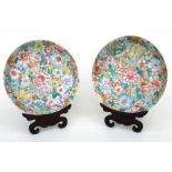 A pair of Chinese millefiore shallow bowls with four character mark to base, on hardwood stands,