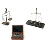 Two pairs of balance scales; together with a mahogany cased set of weights.