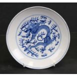 A Chinese blue & white shallow dish decorated with dragon chasing a flaming pearl, blue seal mark to