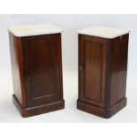 A matched pair of Victorian mahogany bedside cabinets with marble tops and single panel doors, on