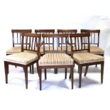 A set of seven Edwardian mahogany dining chairs with overstuffed seats, on tapering reeded front