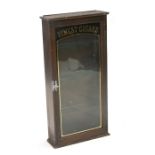 A wall mounted glazed display cabinet with gilt lettering 'Finest Cigars', 44 by 88cms (17.25 by