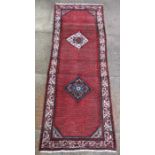 A Persian Hamadan hand knotted woollen runner with two central diamond motifs within a stylised