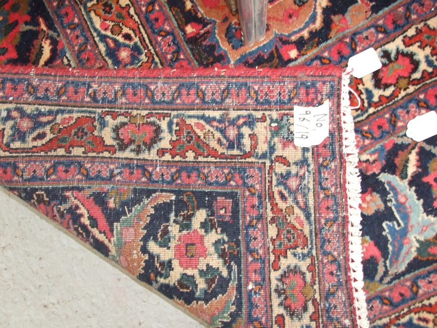 A Persian Kashan hand knotted woollen carpet with central floral gul within floral borders, on a red - Image 4 of 4