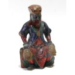 A Chinese polychromed wooden figure depicting a seated dignitary, 23cms (9ins) high.