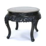 A Japanese circular centre table, the frieze heavily carved with prunus and birds, on carved