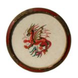 A circular needlework panel depicting a dragon, framed and glazed. 34cm (13.25 ins ) diameter