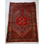 A Persian Hamadan woollen hand knotted rug with central gul within borders, 96 by 140 37.5 by