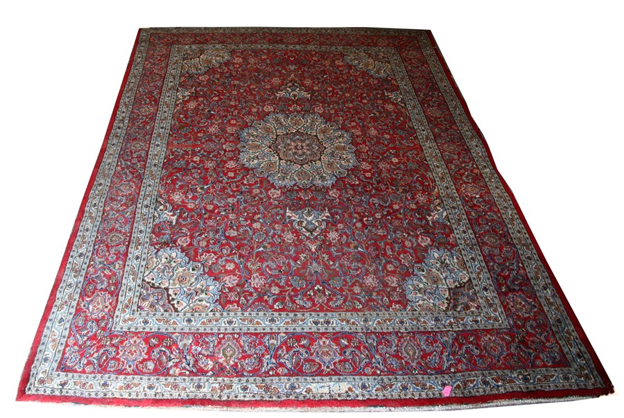 A Persian Mashad hand knotted woollen carpet with central floral medallion within foliate borders,
