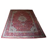 A Persian Mashad hand knotted woollen carpet with central floral medallion within foliate borders,