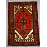 A Persian Hamadan hand knotted woollen rug with stylised central medallion within borders, 103 by