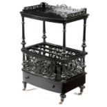 A Victorian ebonised Canterbury, with pierced scrolling fretwork decoration, the raised top with