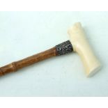 An ivory handled bamboo walking stick with silver collar, 90cms (35.5ins) long.