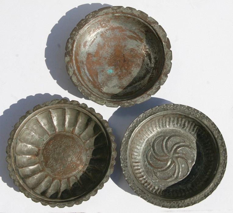 Three Islamic / Indian tinned copper dishes, the largest 25cms (9.75ins) diameter.