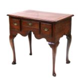 A Georgian oak lowboy, the crossbanded rectangular top above an arrangement of three drawers, on