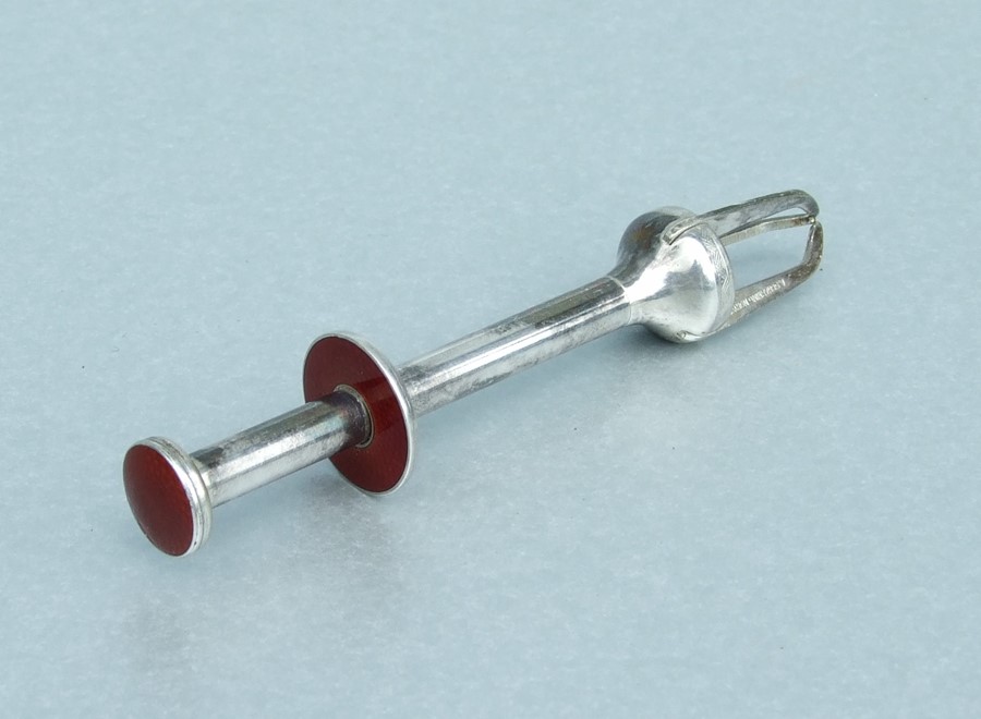 A Scharning Norway silver coloured metal and enamel Art Deco sugar cube grabber or cocktail and