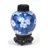 A Chinese blue & white ginger jar of small proportions decorated with prunus, with pierced wooden