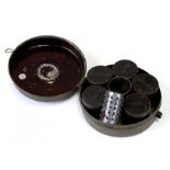 A tin spice box containing five spice jars and a grater, 15cms (6ins) diameter.