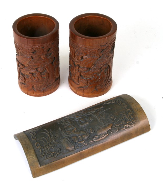 A pair of Chinese bamboo brush pots decorated with figures in a landscape, 15cms (6ins) high);