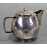A white metal lidded milk jug, initialled, weight 310g, 8.5cms (3.75ins) high.