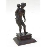 A Burmese bronze figure of a man balancing a ball on his shoulder, mounted on a hardwood stand, 16.