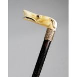An early 19th century ivory handled walking cane, the handle carved with the head of a greyhound,