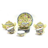 A 20th century Chinese part tea set decorated with foliate scrolls and characters on a yellow