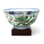 A Chinese footed bowl on stand decorated with a blue and green dragon chasing a flaming pearl with