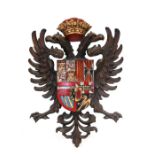 A carved wooden double headed eagle plaque with central painted armorial, 33cms (13ins) wide.
