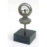 A Wilmot Calometer on a radiator cap mounted on a plinth.