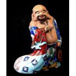 A Chinese pottery figure of a robed man holding a fan, 20cms (8ins) high.
