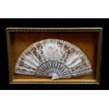 A 19th century fan with mother of pearl sticks and lace leaf decorated with three vignettes with