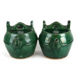 A pair of 19th century Chinese Shiwan green glazed wine pot, 22cms (8.75ins) high.