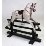 A 19th century Ayres type carved wooden and painted rocking horse, raised on a painted pine stand,