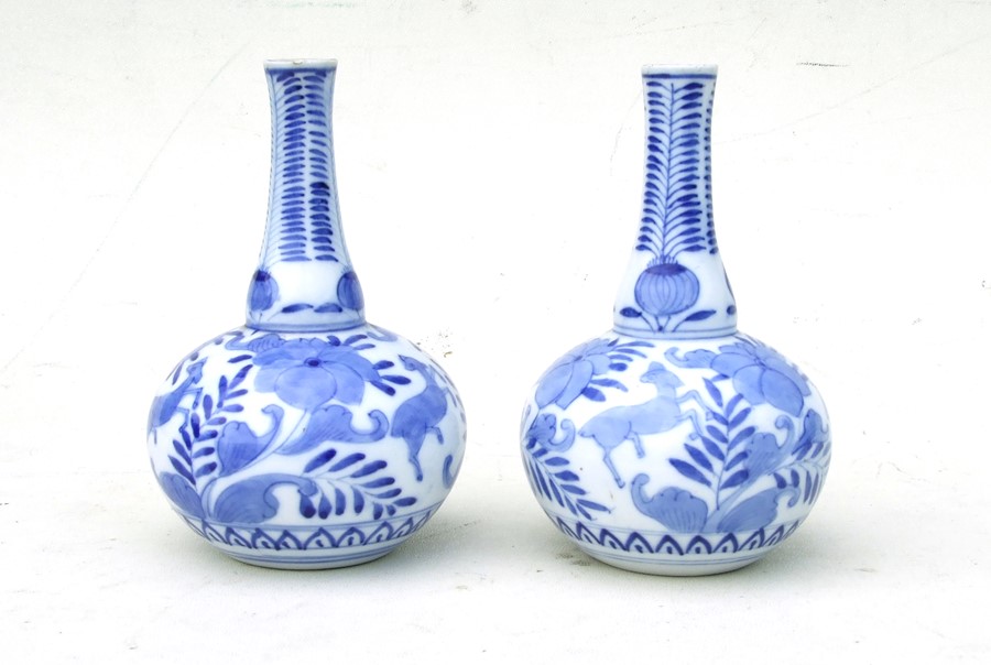 A pair of Chinese blue & white bottle vases decorated with deer and flowers, 15cms (6ins) high (2).